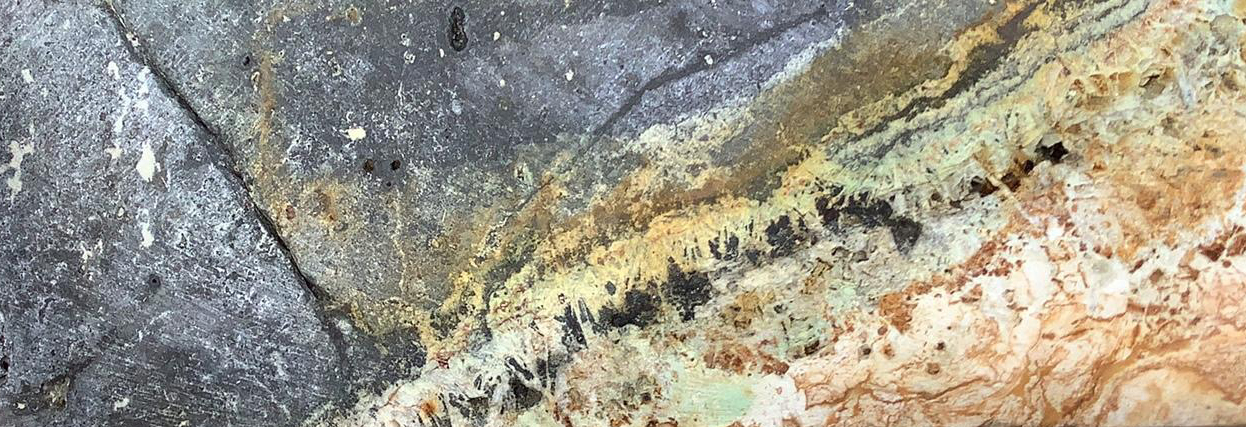 Vergrösserte Ansicht: Hydrothermisch verändertes Gestein mit Kupfer- und Goldmineralisierung